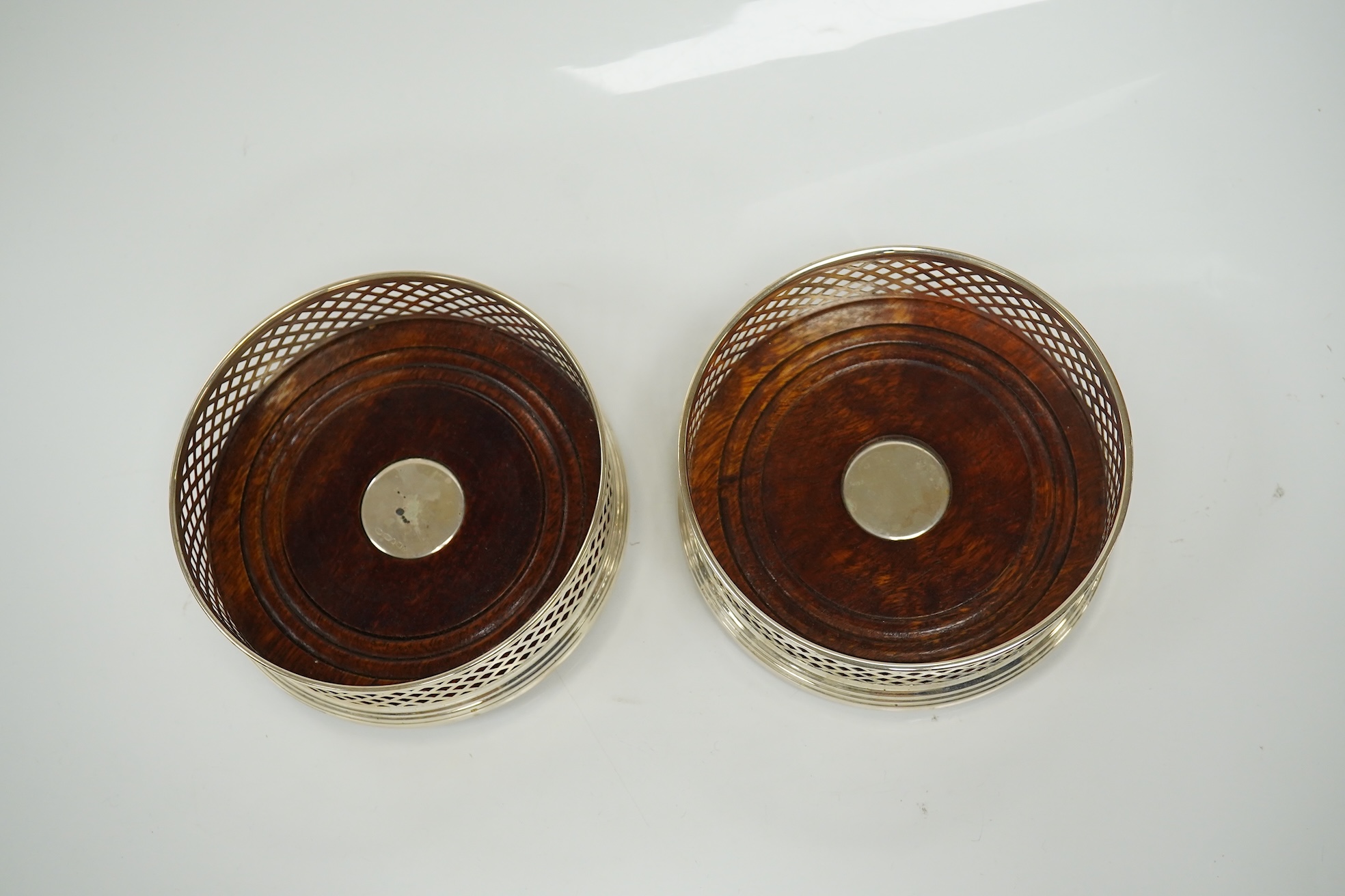 A pair of modern pierced silver mounted wine coasters, by W.I. Broadway & Co, Birmingham, 2000, diameter 12.2cm. Condition - good